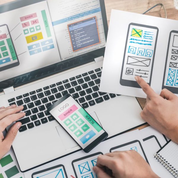 Designers are drawing a landing page for UX app development. 